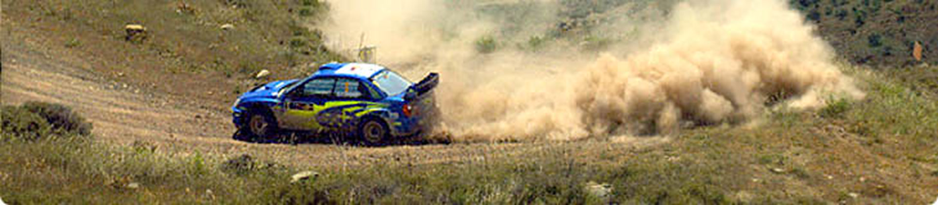 Rally autó kavicsos úton, por és kövek repülnek